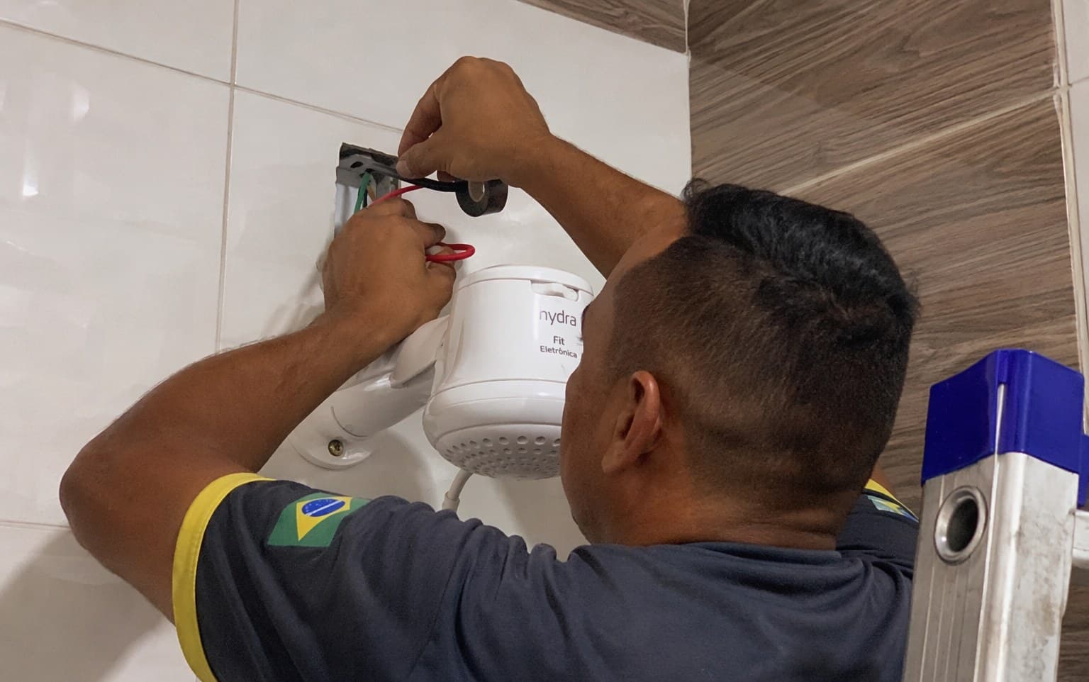 Instalação de chuveiro elétrico em banheiro de azulejo claro